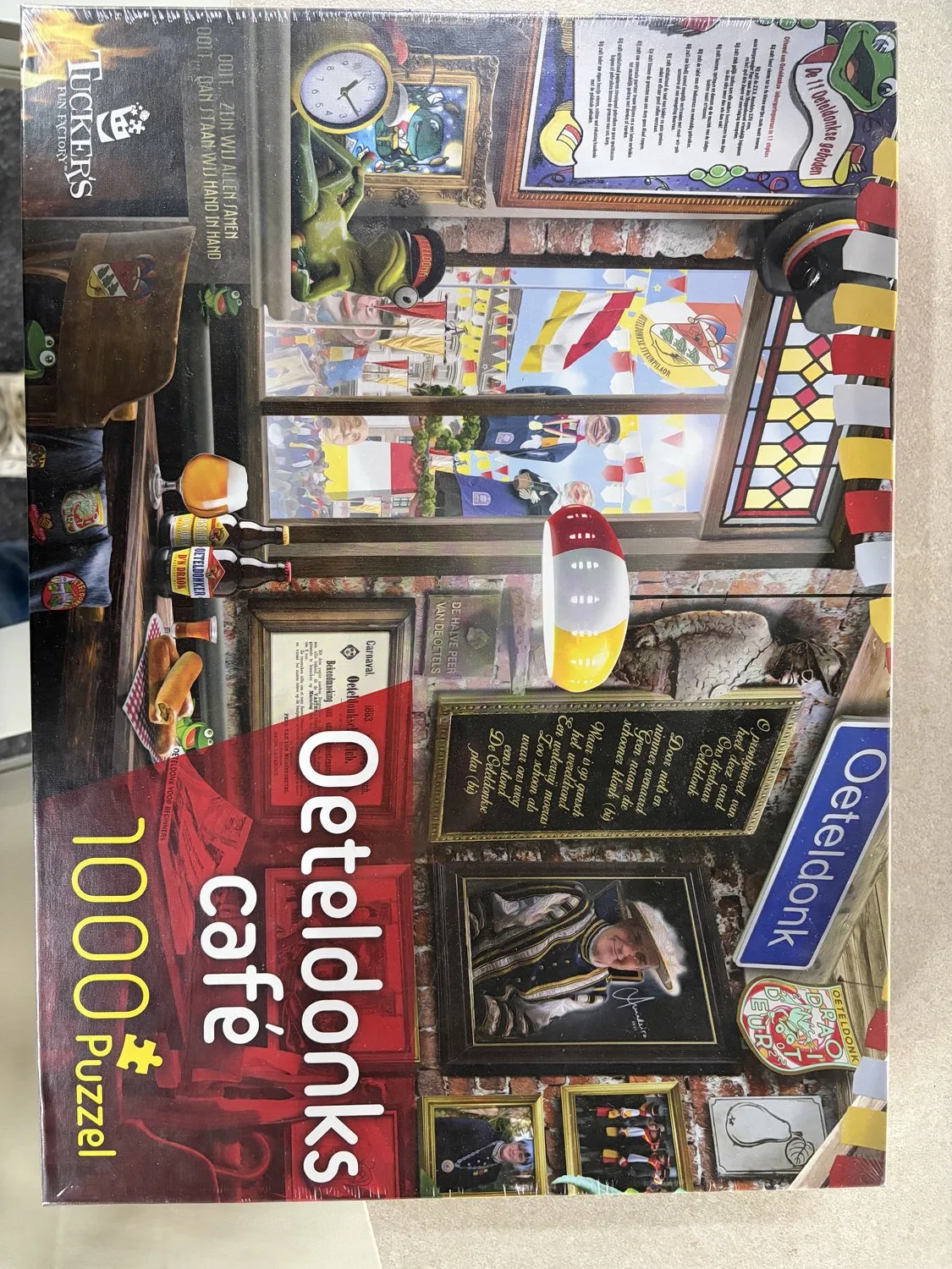 Oeteldonks Café ( puzzel 1000 st) von Tucker's Fun Factory, Ausgabe Rot, Wit en geel – Schachtel
